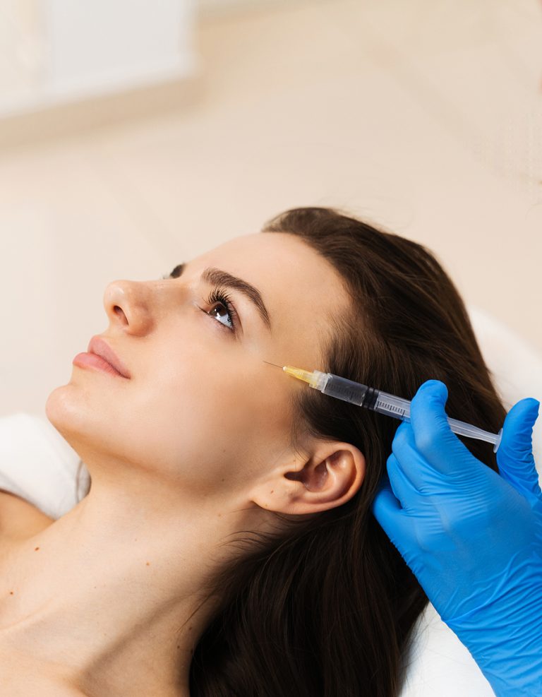 A young woman receiving a cosmetic injection to smooth wrinkles at a clinic